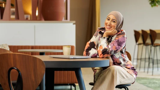 Decoratieve foto van een vrouwelijke collega van de Regionale Belasting groep, welke direct in de camera kijkt.