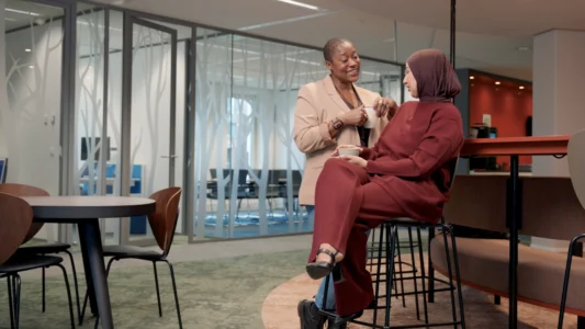 Decoratieve foto van een tweetal vrouwelijke collega's van de Regionale Belasting groep, welke direct in de camera kijken.